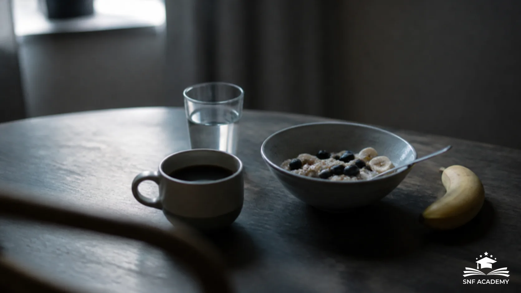 Tasse Kaffee, Glas Wasser, Haferschale mit Beeren und Banane auf einem dunklen Holztisch