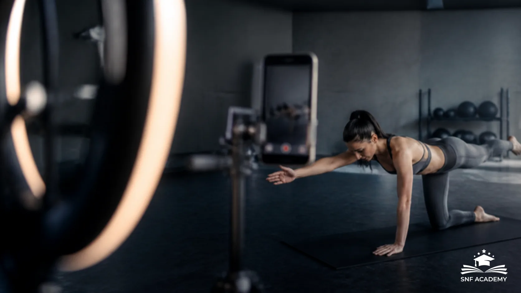 Fitnesstrainerin filmt eine Übung mit Smartphone und Ringlicht