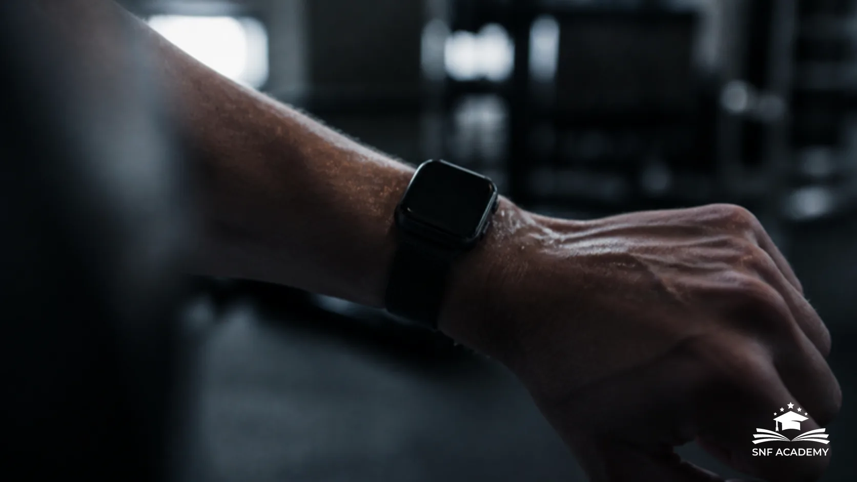 Fitnessuhr am Handgelenk nach dem Training im unscharfen Fitnessstudio