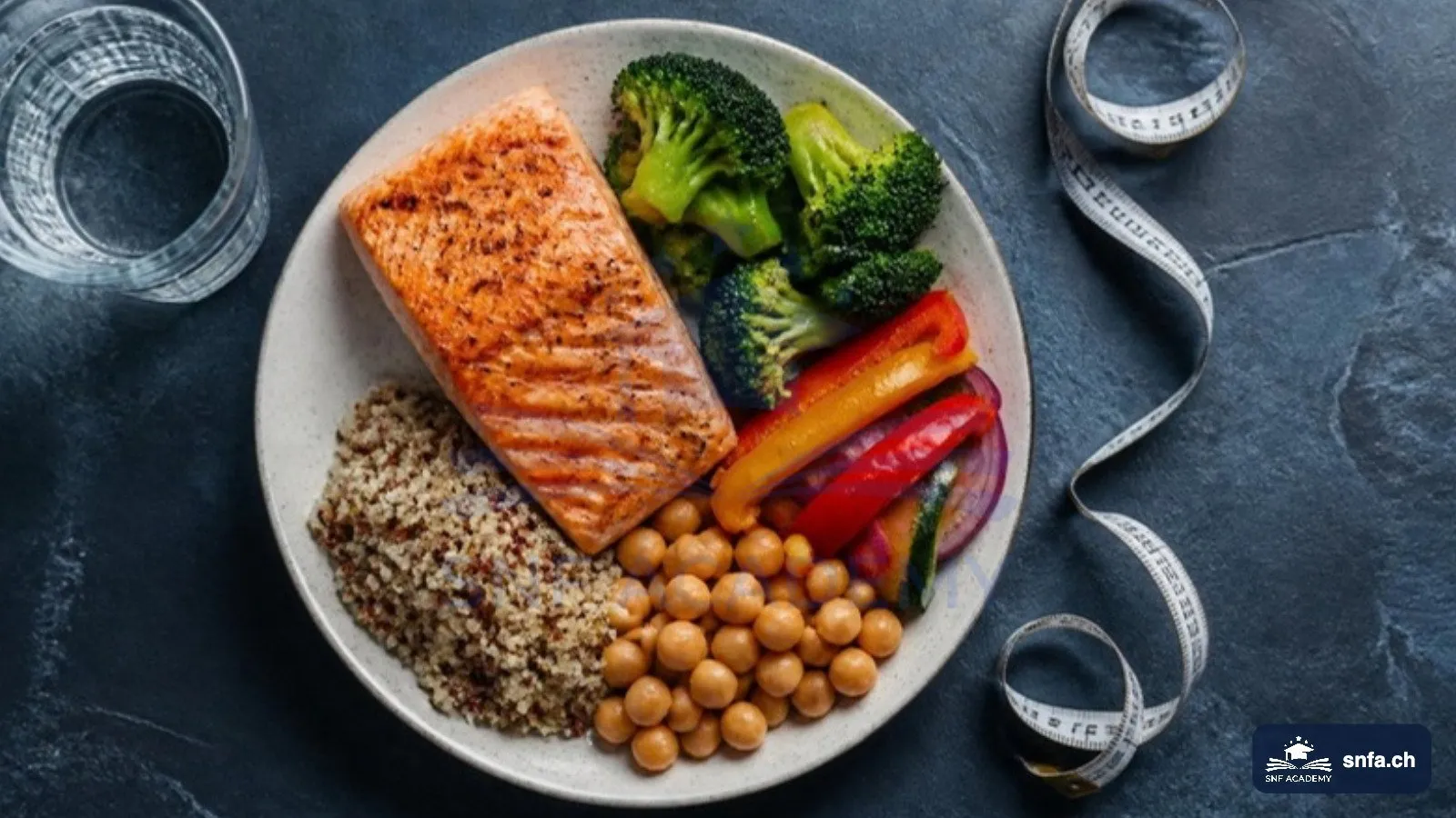 Abnehmen in den Wechseljahren: ausgewogener Teller mit Lachs, Gemüse, Quinoa und Kichererbsen neben Massband – SNF Academy