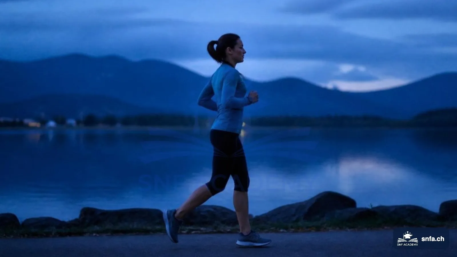 Zone 2 Training: Läuferin joggt in lockerem Tempo am See in der Abenddämmerung – SNF Academy